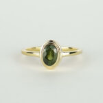 Ring met dubbele zetkast en een groene ovale saffier.