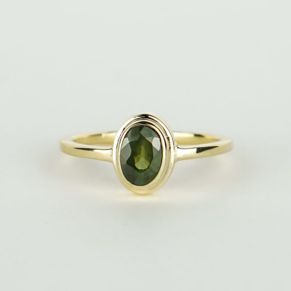 Ring met dubbele zetkast en een groene ovale saffier.