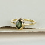 Ring met ovale groene saffier en dubbele zetkast
